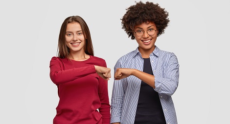 Two women stood side by side doing a fist bump